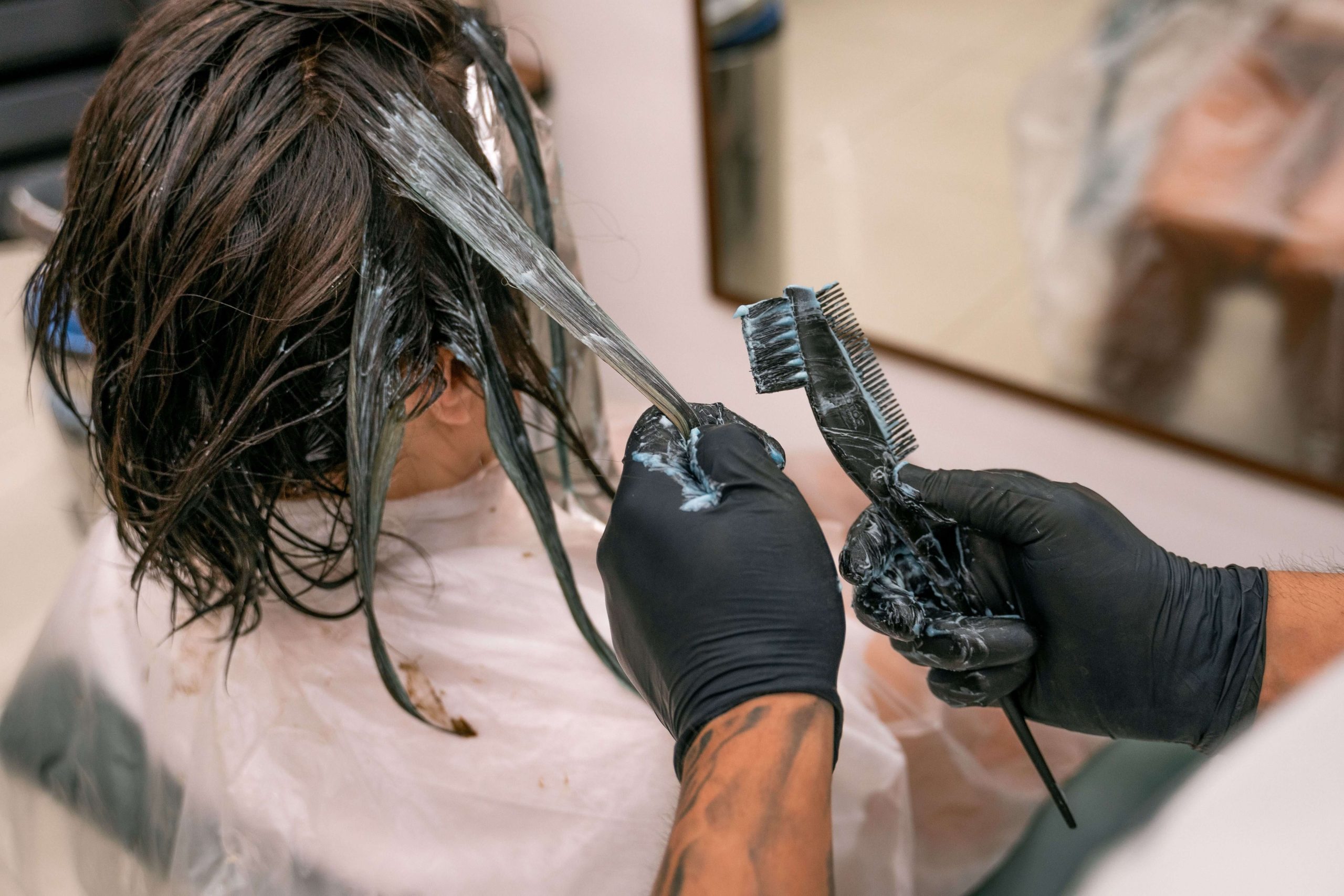 Stylist applying Brazilian Blowout treatment to hair sections
