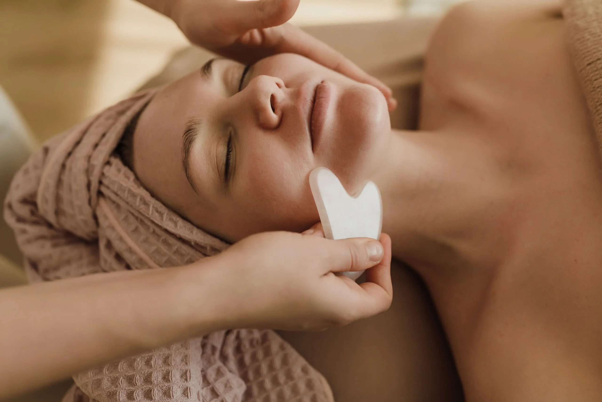 Aesthetician performing a sculpting facial lymphatic drainage massage along the jawline